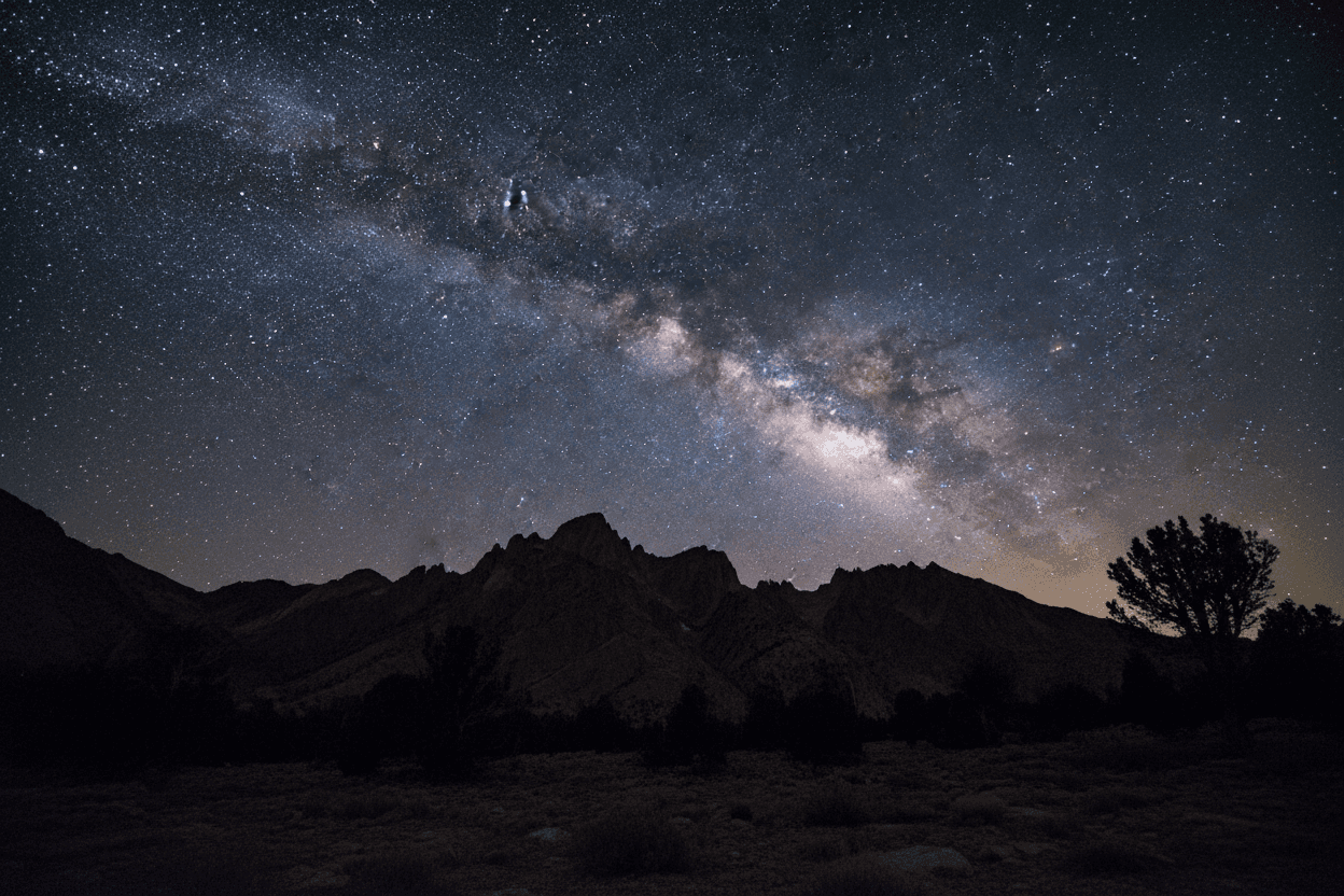 은하수가 장엄하게 아치형으로 솟아오른 별이 빛나는 밤하늘과 실루엣 산맥 아이폰 배경화면.