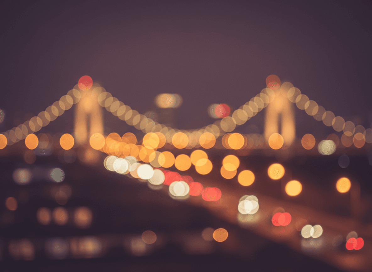 밤의 따뜻한 도시 불빛이 부드럽게 흐려진 보케 배경, 얕은 심도, 낭만적이고 몽환적인 분위기의 컴퓨터 배경화면.