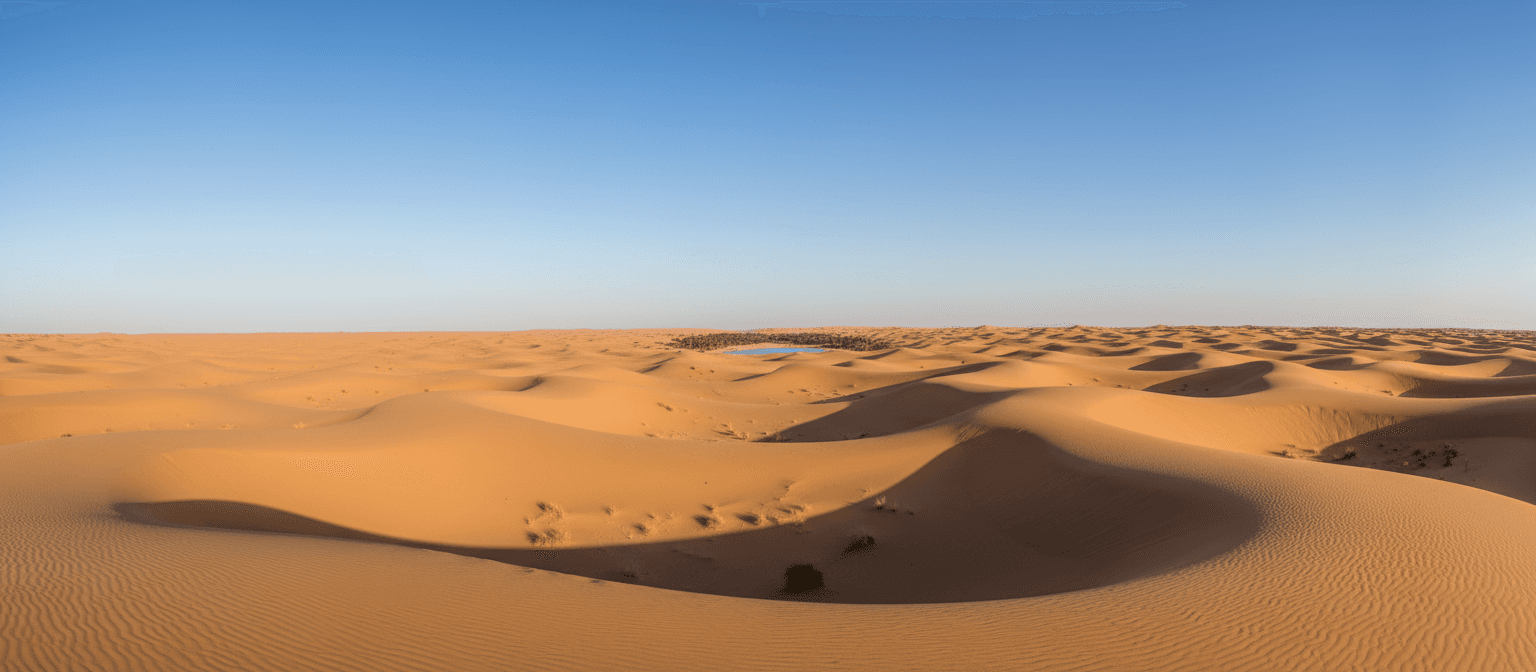 푸른 하늘 아래 끝없이 펼쳐진 사막 풍경의 평온한 4K 배경화면, 완만한 모래 언덕, 부드러운 그림자.