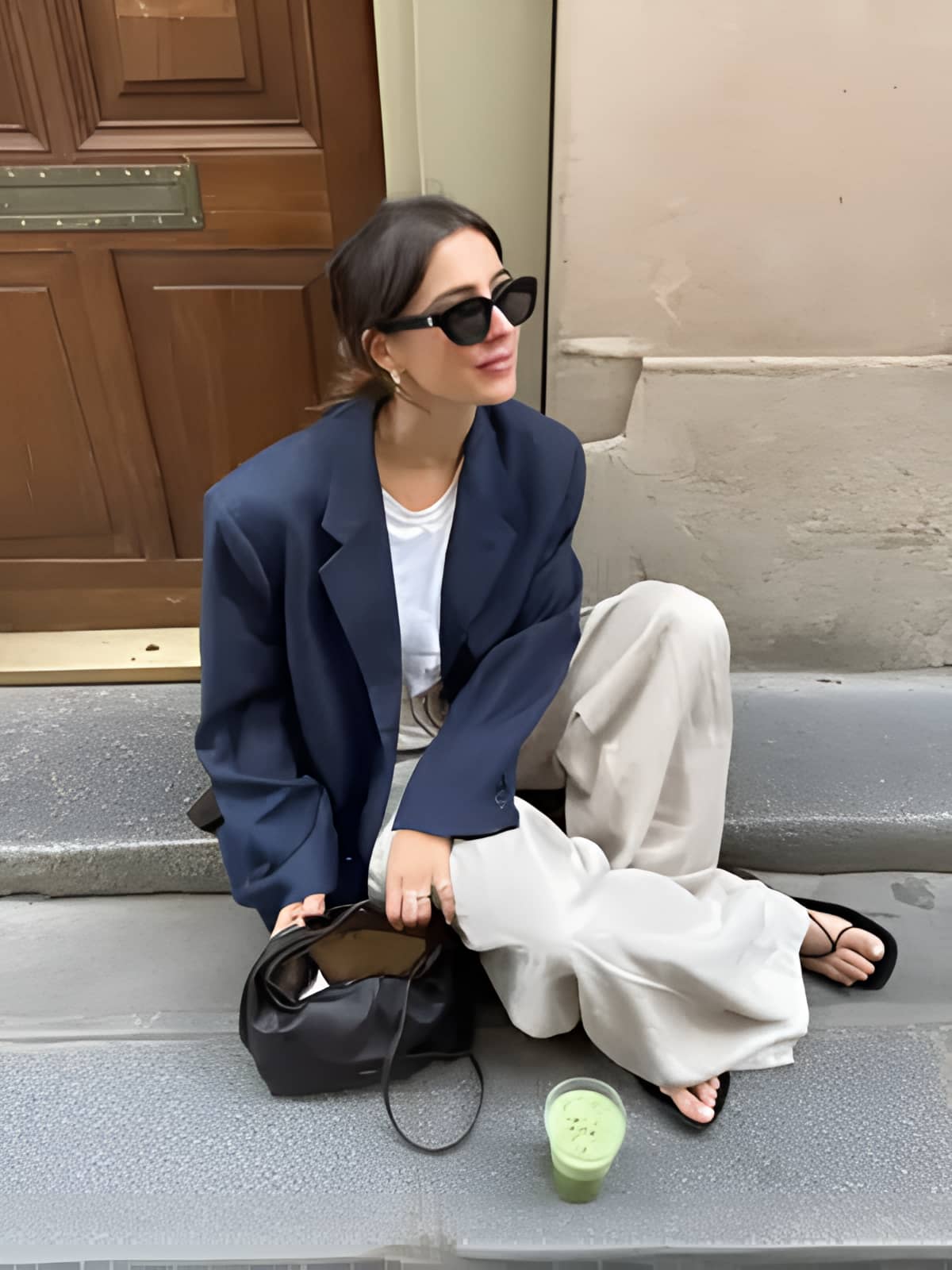 A woman showcasing a chic Higgsfield Soul aesthetic with an oversized navy blazer, wide-leg trousers, and sunglasses on city steps.