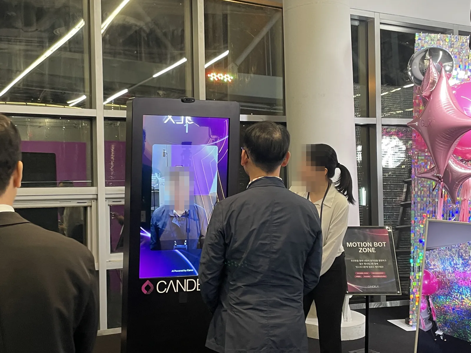 운영 스태프 안내를 받으며 CANDELA 키오스크에서 촬영하는 참가자
