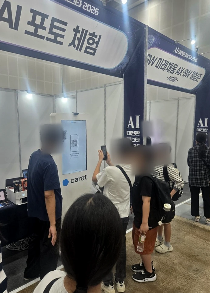 운영자의 안내를 받으며 키오스크를 이용하는 참가자들