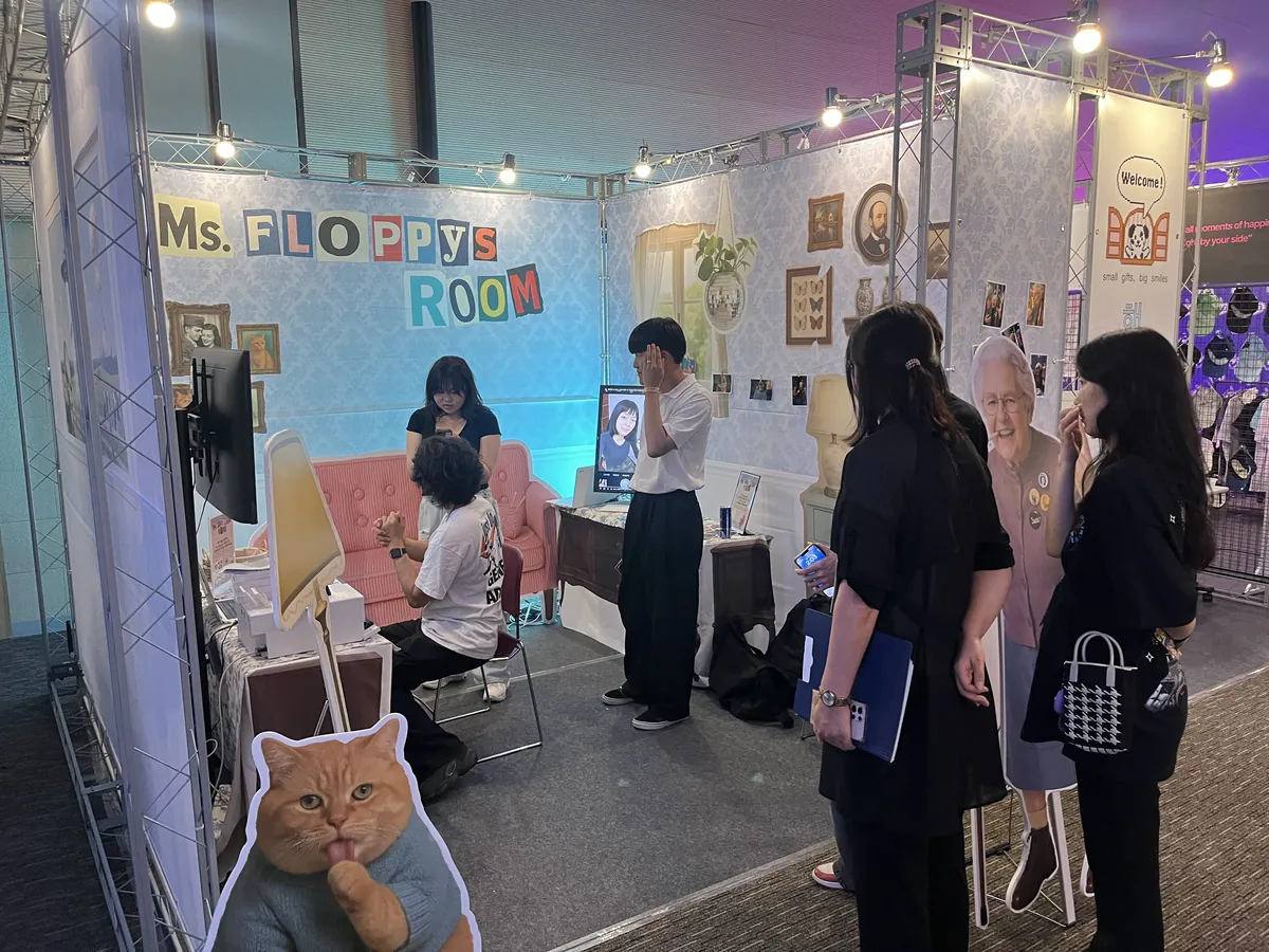 Ms. FLOPPY's ROOM 세트 안에서 AI 프로필을 만드는 관람객 — 광주 김대중컨벤션센터