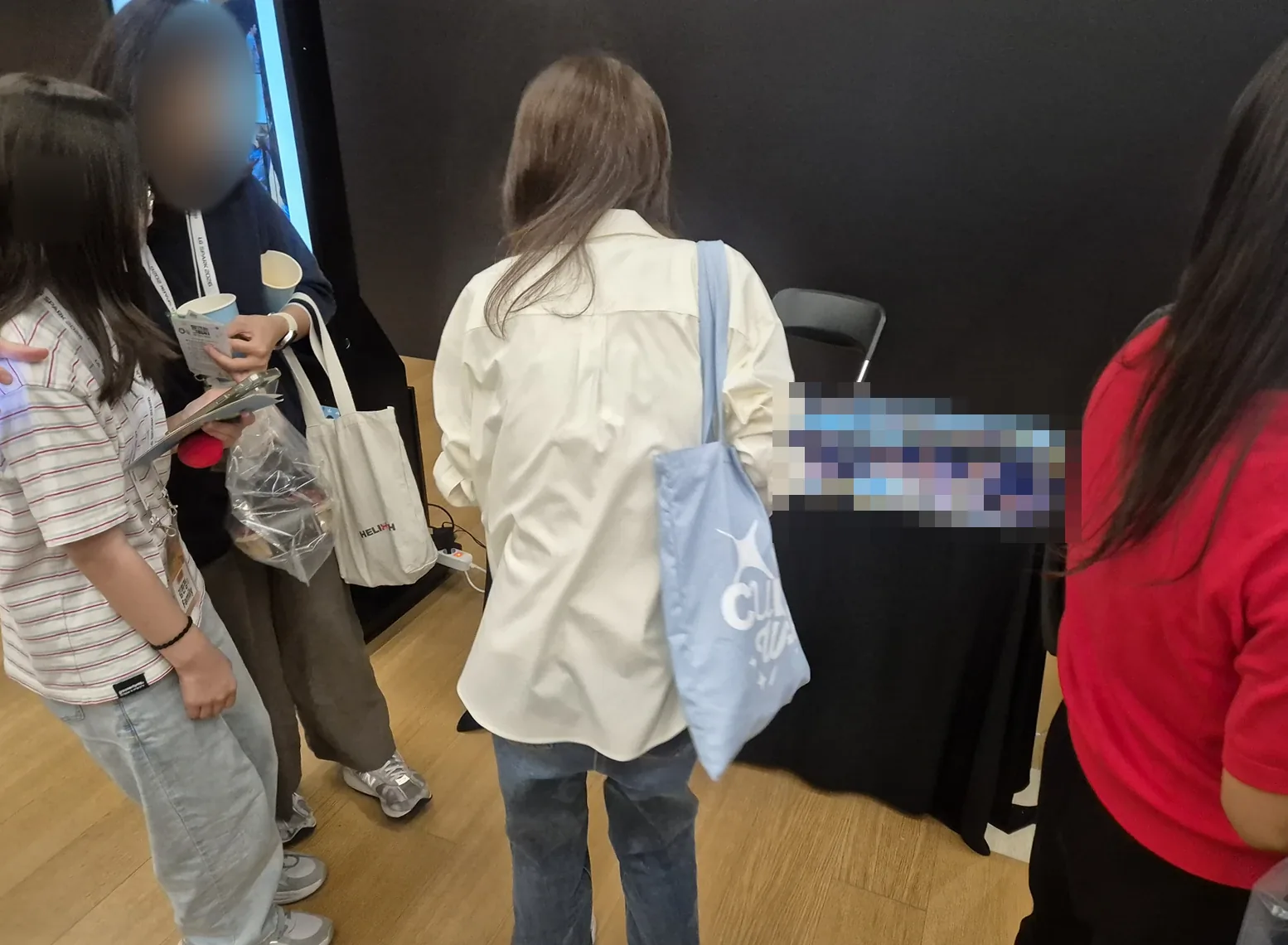 인화 결과물을 살펴보는 참가자들과 운영 테이블